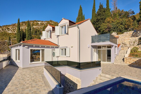 A modern house with a swimming pool, a stone staircase, and a view of the surrounding hills. - Villa Aguzin - Four Bedroom Villa, Sleeps 8 (Osojnik)
