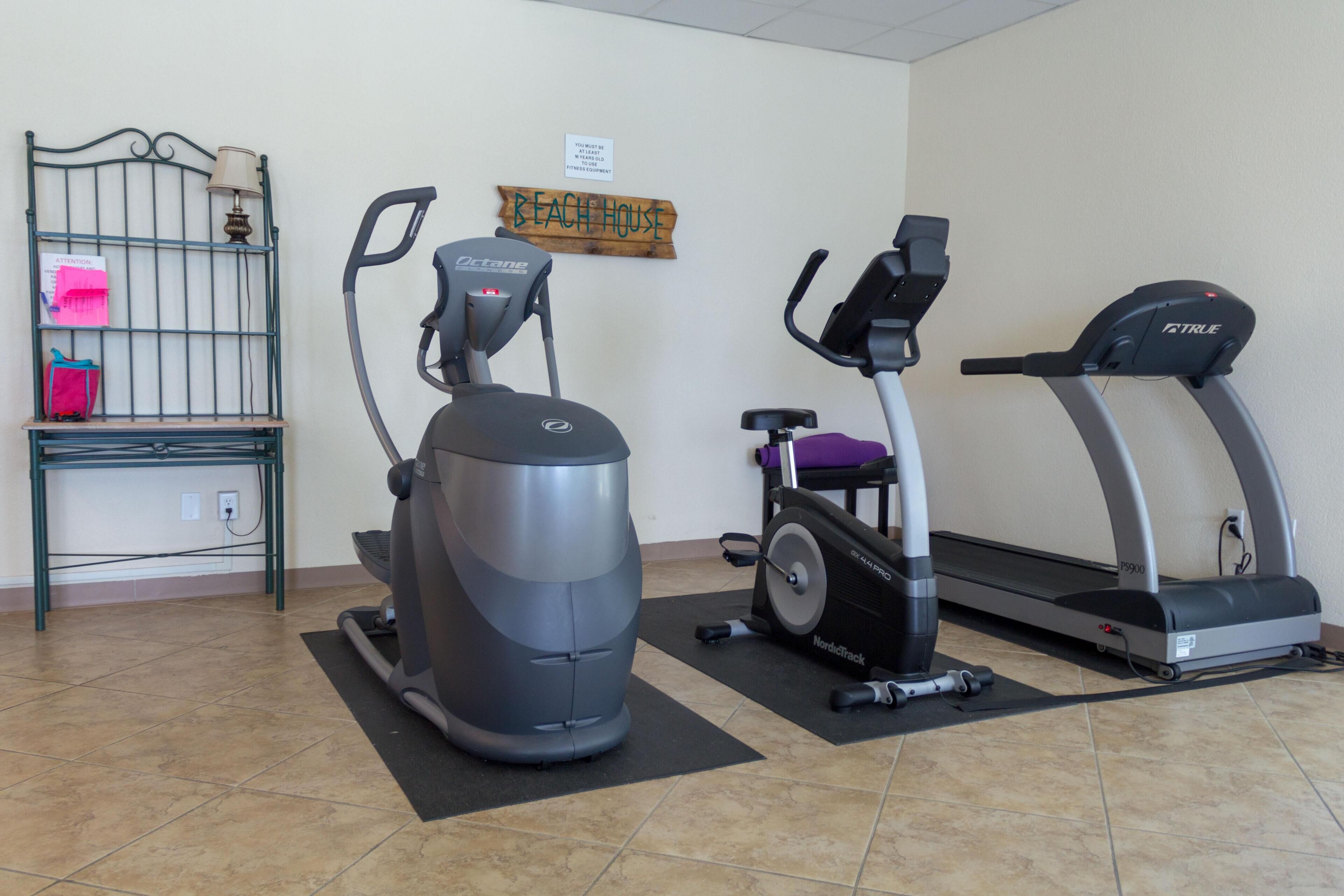 Ein Fitnessbereich mit einem Crosstrainer, einem Ergometer und einem Laufband.