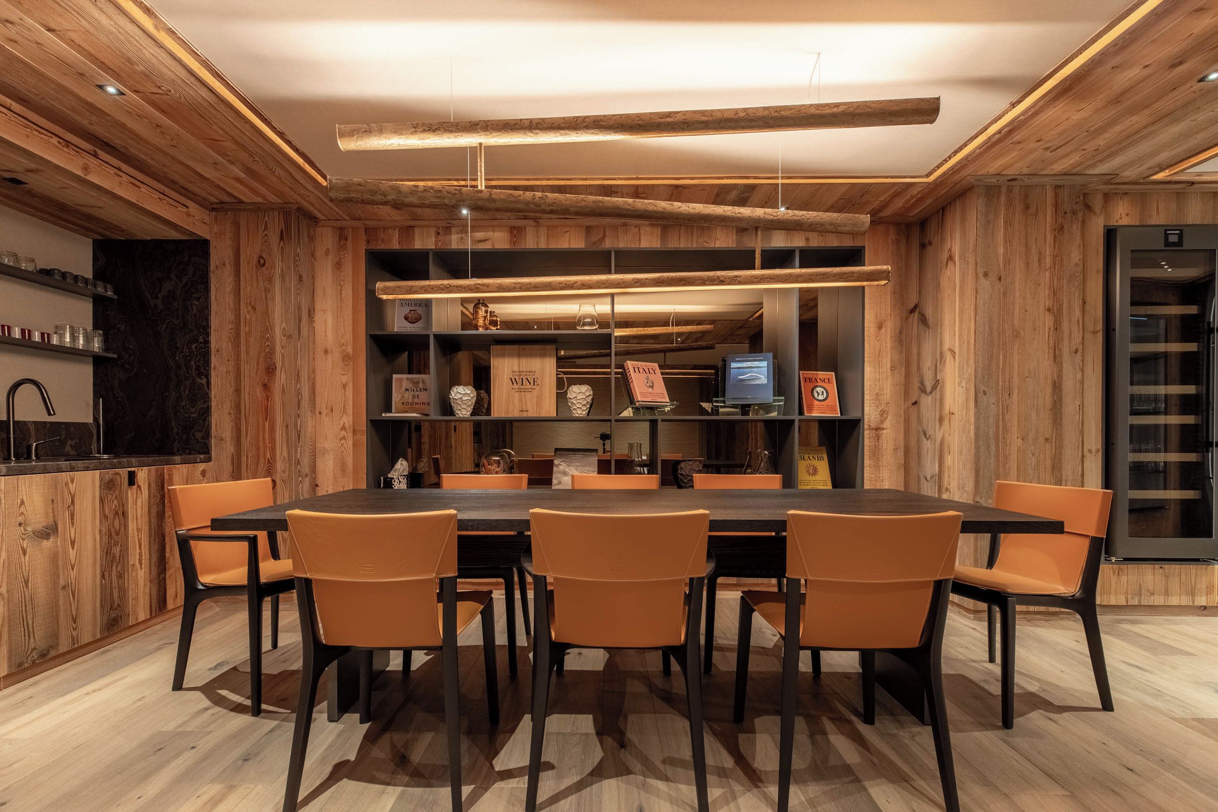 Un'area pranzo moderna con arredamento in legno, un tavolo lungo e sei sedie.