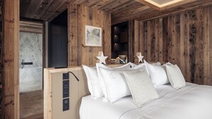 Un dormitorio con cabecera de madera, ropa de cama blanca y una lámpara con forma de estrella.