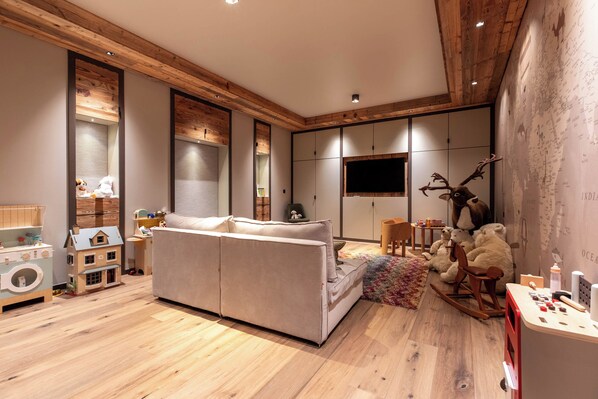 A modern living room with a sofa, wooden flooring, a television, and a wall with a map.