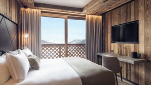 Ein Hotelzimmer mit einem großen Bett, einem Schreibtisch und einem Fernseher.