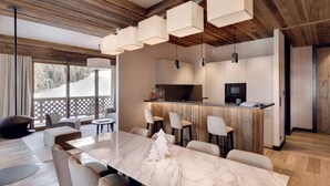 Una cocina moderna con encimera de mármol, techo de madera y asientos tipo barra.