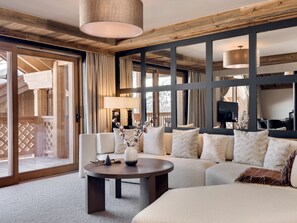 A modern living room with a large sectional sofa, a round coffee table, and a fireplace.