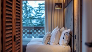 Un dormitorio con cama, almohadas y mesita de noche.