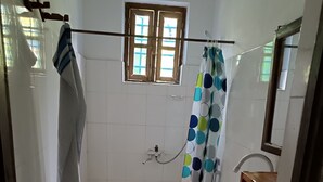 A bathroom with a toilet, a sink, a shower, and a window. - Jambiani Holiday House (Jambiani)