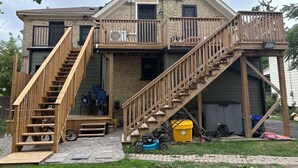 A two-story house with a wooden staircase and balcony.