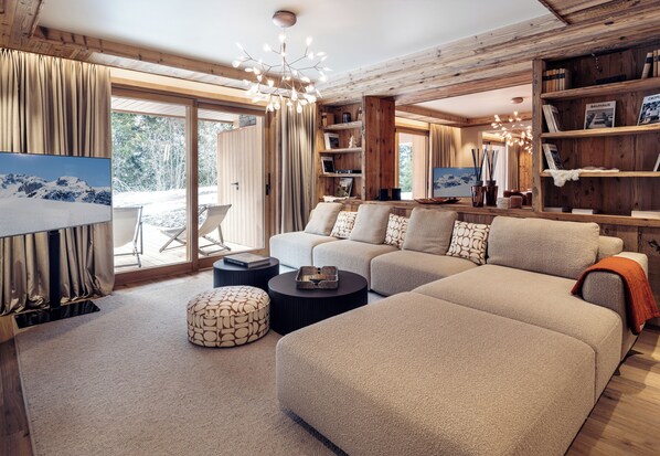 Una sala de estar acogedora con un sofá modular, una mesita redonda y una estantería.