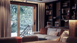 Una sala de estar acogedora con un sofá, una mesa de centro y una estantería llena de libros y objetos decorativos.