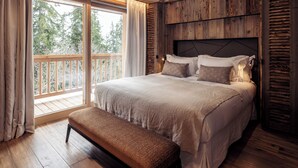 A bedroom with a large bed, wooden headboard, and a bench.