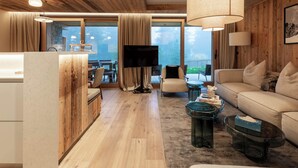 A modern living room with wooden walls, a large TV, a sofa, and a coffee table.