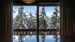A room with a large window reflecting a snowy mountain landscape.