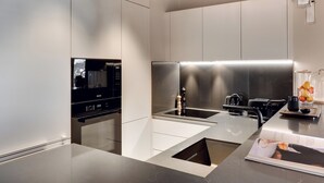 Una cocina moderna con microondas integrado, electrodomésticos de acero inoxidable y una encimera elegante.