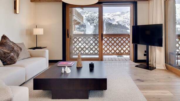 Una sala de estar moderna con sofá, mesa de centro, lámpara y televisor.