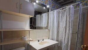 A bathroom with a toilet, sink, and shower curtain.