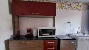 A kitchenette with a microwave, coffee maker, and a sink.