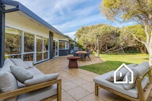 Enjoy outdoor dining and relaxation in this spacious patio area with a dining set and fire pit.