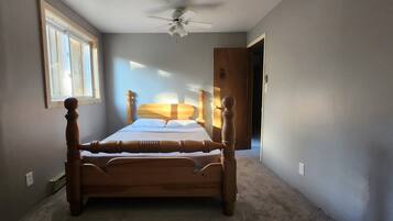 Un dormitorio con cama con dosel, ventilador de techo y ventana que proporciona luz natural.