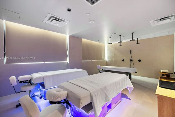 A modern spa room with a massage table, a treatment chair, and a wall-mounted shower. - 601 RESIDENCES SKY FLOOR 1BR UNIT #2611 (Miami)