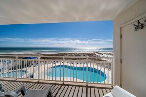 A balcony with a view of a beach and a swimming pool. - Sugar Beach 245 (Orange Beach)