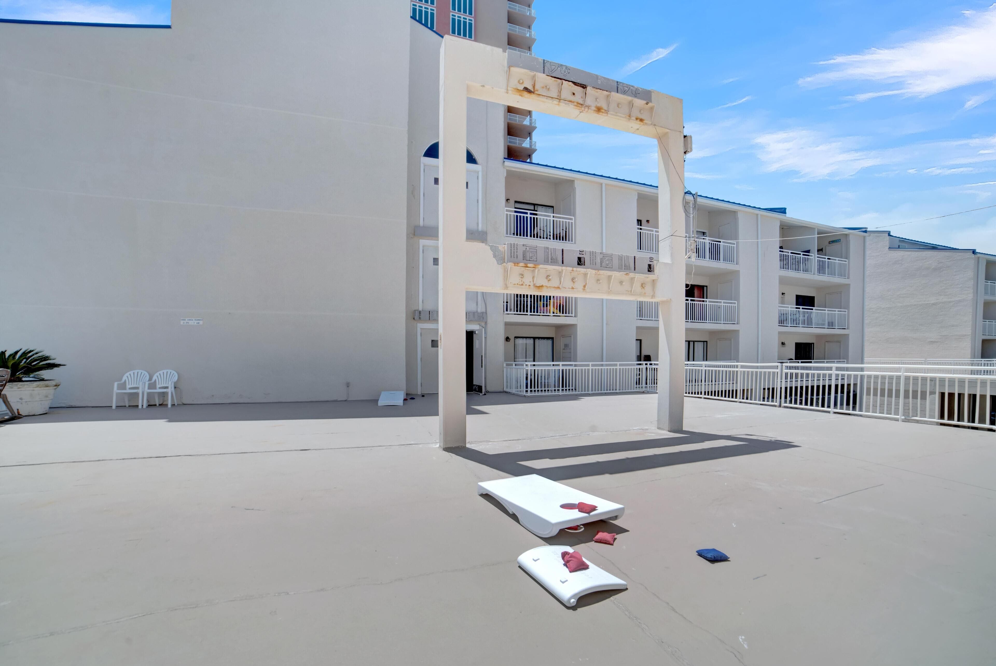 A multi-story building with balconies, a concrete floor, and white railings.
