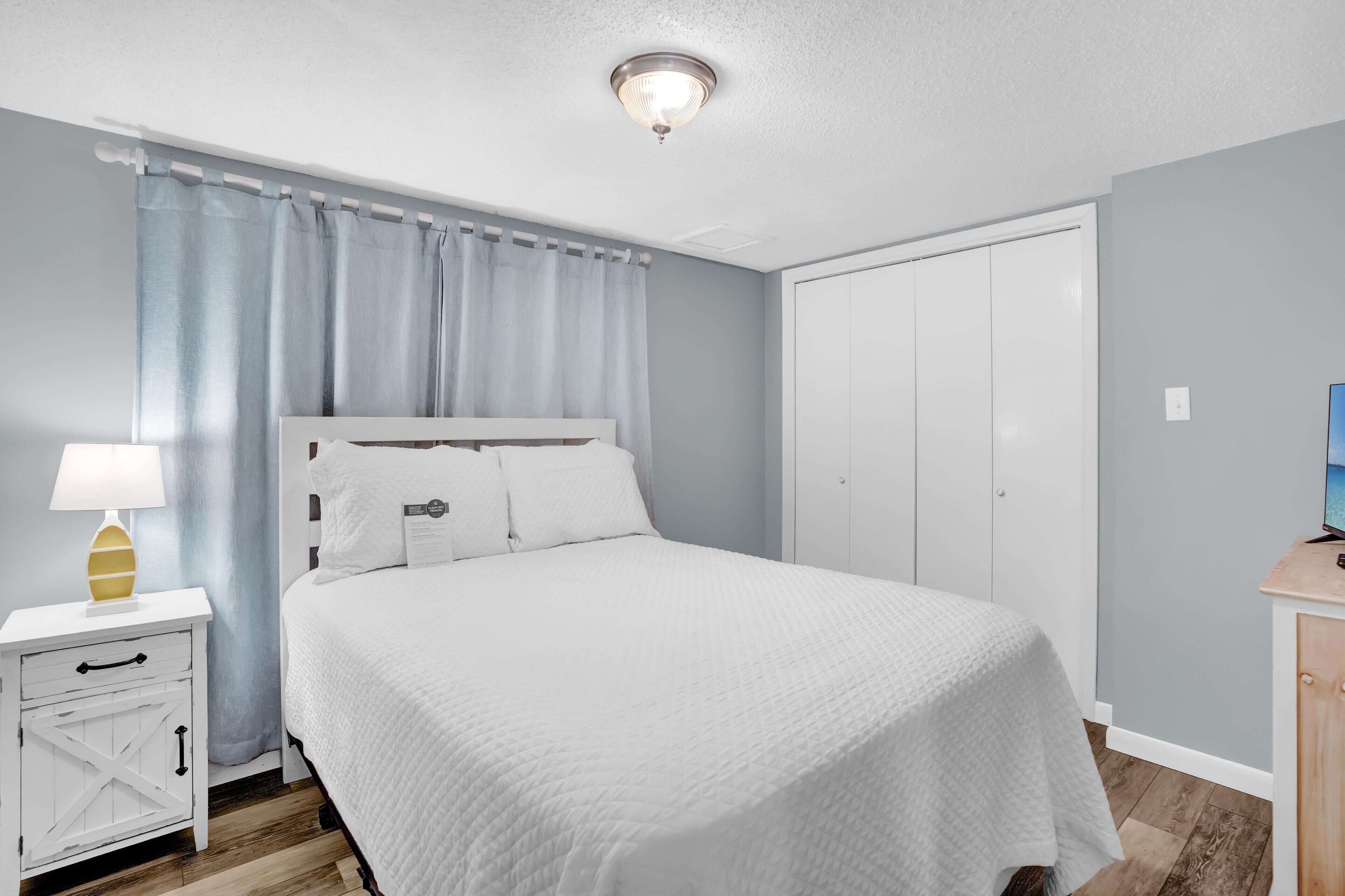 Una camera da letto con un letto, un comodino e un armadio chiuso.
