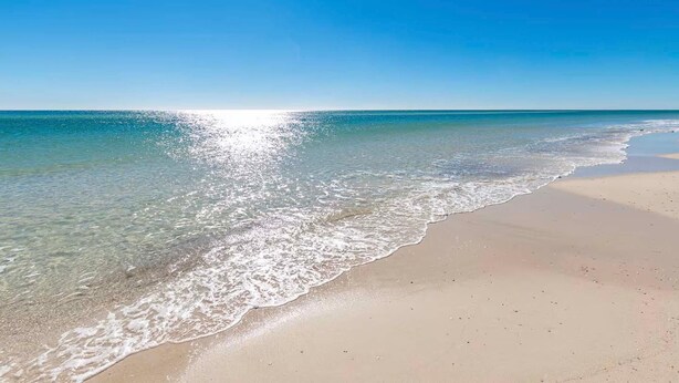A beach with clear water, a sandy shore, and a clear sky. - Sugar Beach 323 (Orange Beach)