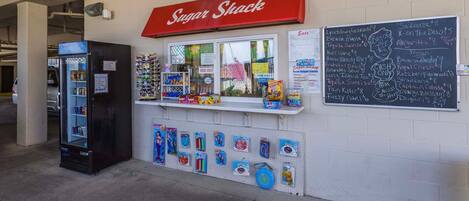 ’Sugar Shack’ -niminen ruokakioski, jossa on ruokalista ja jääkaappi, joka on täynnä juomia.