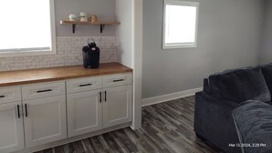 A kitchen with white cabinets, a wooden countertop, and a coffee maker. There is a window and a door leading to another room. - Close to Lake G’VILLE 3-BR house with AC, BOAT BARN-24’x48’, WiFi in Albertville (Albertville)