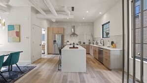 Une cuisine moderne avec un îlot central, des meubles en bois et une grande fenêtre.