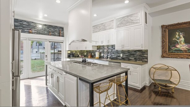 A modern kitchen with white cabinetry, a large island, and a black and white backsplash. - Franklin Manor-columbus Downtown Luxury Estate (Columbus)