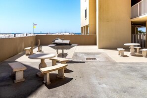 Un espacio al aire libre con asador, mesas y bancos.