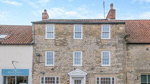 A stone building with a white door and multiple windows, labeled 'WARRINGTON.' - Warrington House-UK48465 (Thornton-le-Dale, near Pickering)