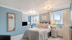 A bedroom with a bed, bedside tables, a TV, and a window. - Warrington House-UK48465 (Thornton-le-Dale, near Pickering)