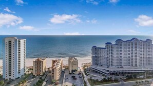 A coastal hotel complex with multiple high-rise buildings, a beach, and a parking area. - The Whaler B3 (Gulf Shores)