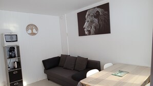 A modern living room with a grey sofa, a wooden coffee table, a television, and a framed picture on the wall. - Rental La Mongie Tourmalet at the foot of the slopes studio sleeps 5 (Bagnères-de-Bigorre)