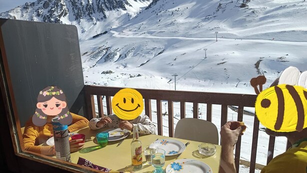 A dining table with plates, cutlery, and a bottle, set against a snowy mountain backdrop. - Rental La Mongie Tourmalet at the foot of the slopes studio sleeps 5 (Bagnères-de-Bigorre)