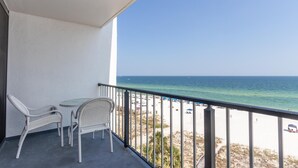 Uma varanda com vista para a praia e o oceano.