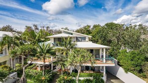 A modern two-story house with a flat roof, surrounded by lush greenery and palm trees. - Apartment 2 Surfside. Combining an amazing beachside location, just 500m from town (Byron Bay)