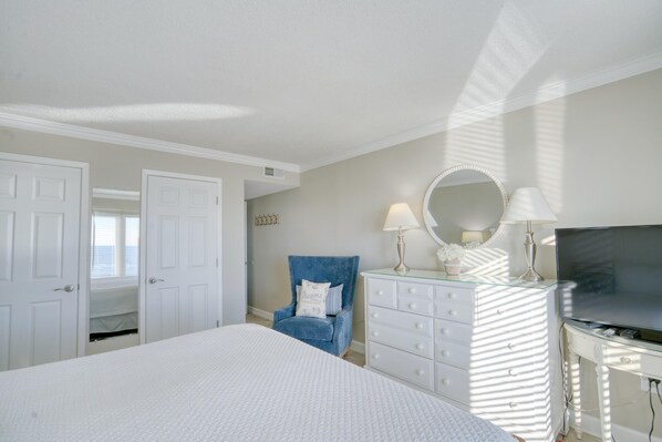 A bedroom with a bed, a dresser, a TV, and a chair. - The Breakers 44 (Orange Beach)