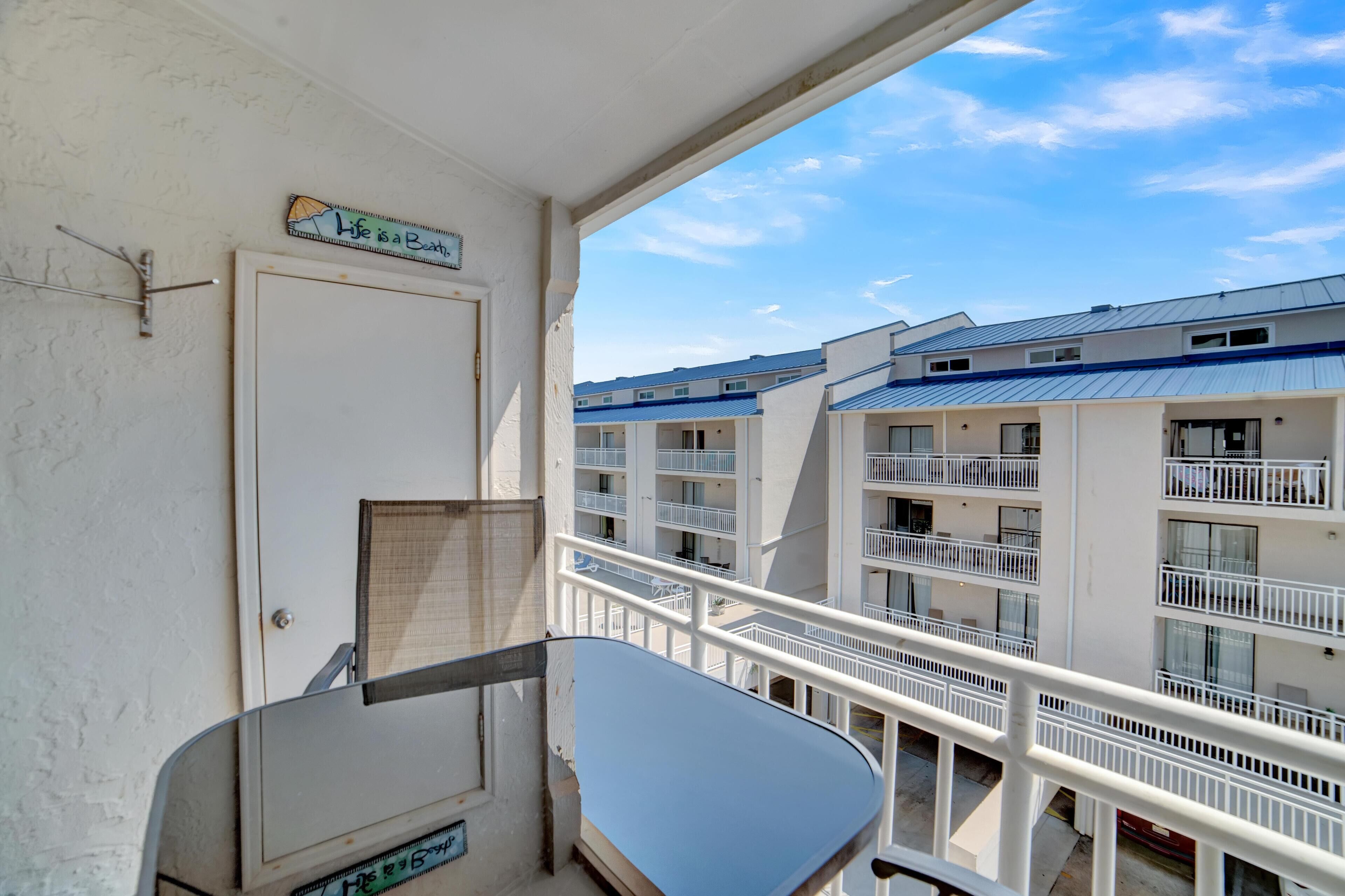 Een balkon met uitzicht op een meerlaags gebouw met balkons en leuningen.
