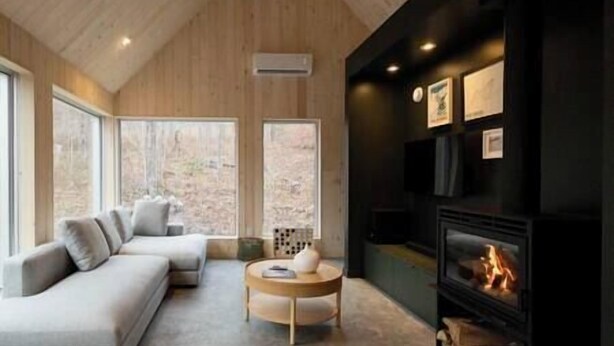 A modern living room with a large sofa, a coffee table, and a fireplace.
