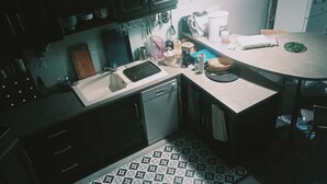 Uma cozinha compacta com pia, lava-louças e mesa de jantar com cadeiras.