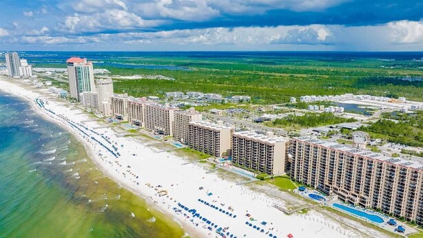 A coastal hotel with multiple high-rise buildings, a beach, and a marina. - Summer Salt 24181 (Orange Beach)