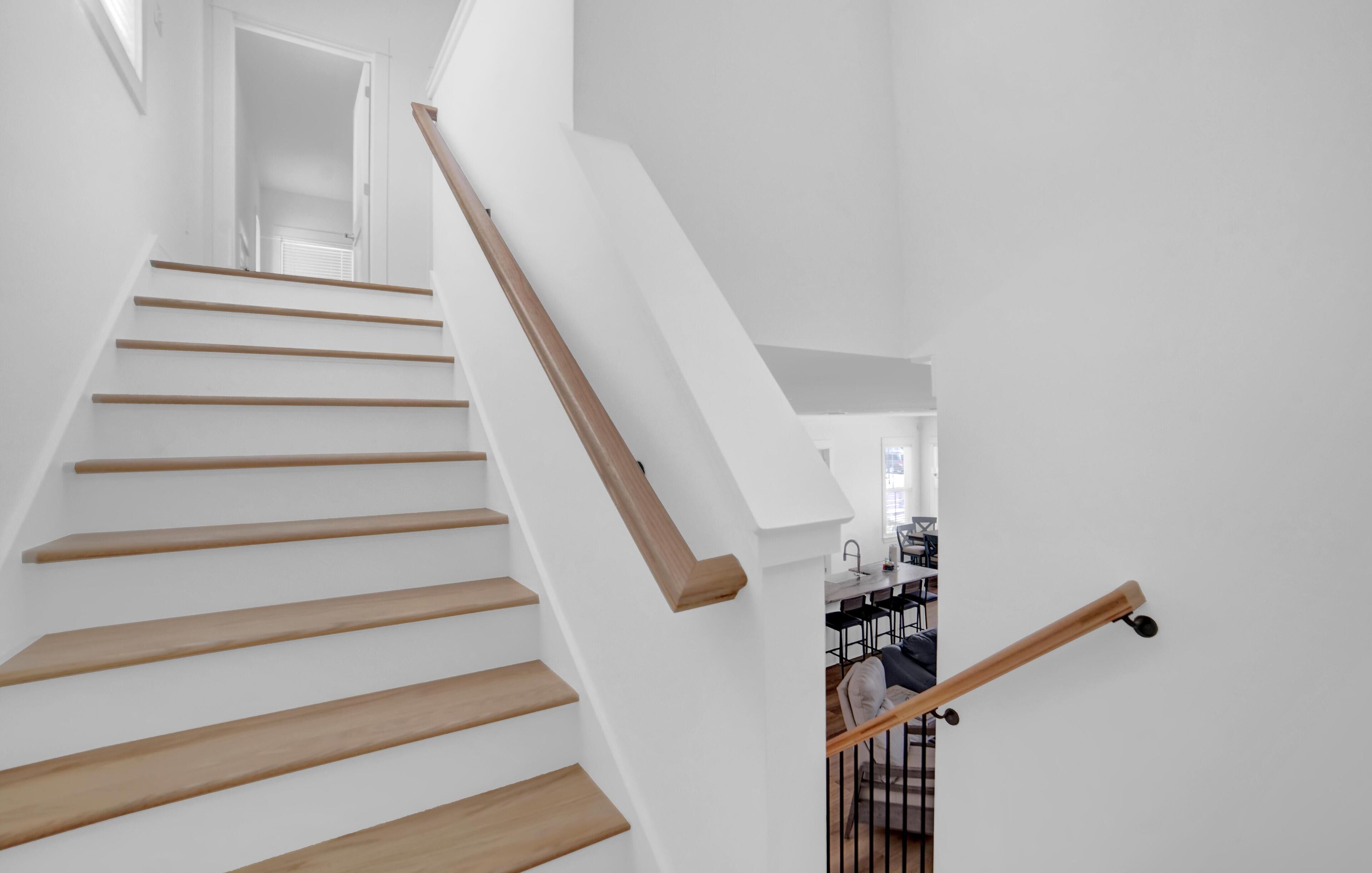 A staircase with wooden steps and a white wall.