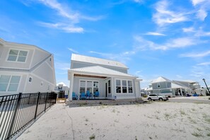 A beachfront property with a white house, a covered porch, and a sandy beach. - Summer Salt 2774 (Orange Beach)