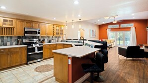 Una cocina moderna con armarios de madera, electrodomésticos de acero inoxidable y una isla central.