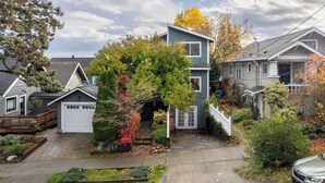 A residential area with houses, a driveway, and a car.