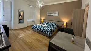 Un dormitorio con cama, mesita de noche, lámpara y espejo.