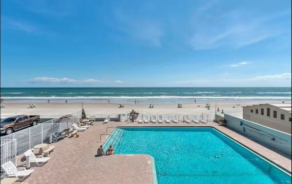 A swimming pool with a view of the beach and ocean.